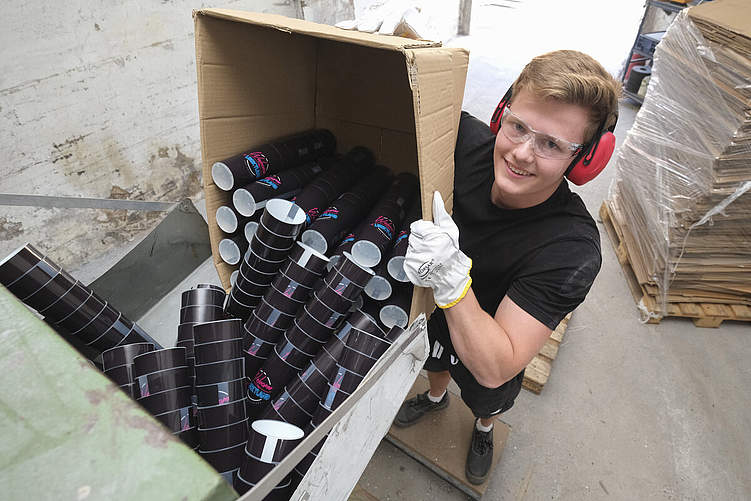 Ab in den Schredder: Finn Schwekendiek leert einen Karton mit 320 Bechern. Das Granulat verkauft das Unternehmen an den Rohstofflieferanten. Foto: Markus Prell