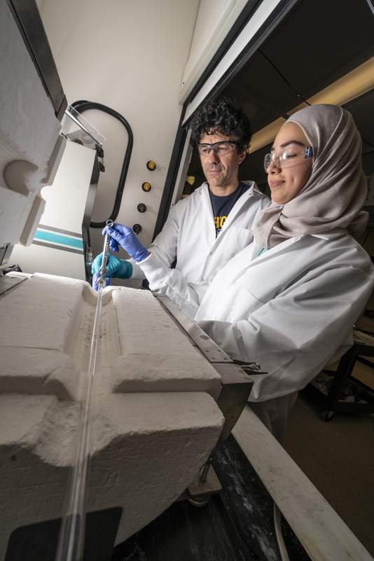 Universität Michigan: Forscher richten ein Reaktionsgefäß für Tests in einem Ofen ein. Foto: Eric Eggly Photography